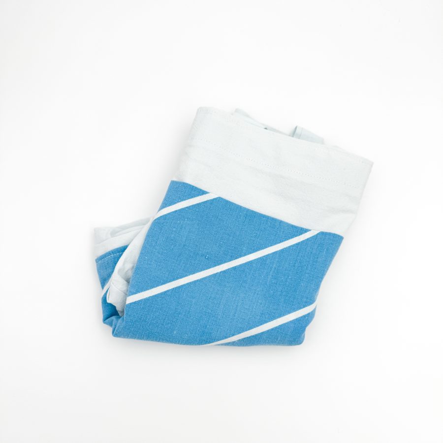Dette net er af et lyseblåt materiale med en mørkeblå lomme med striber. Hanken er lyseblå.