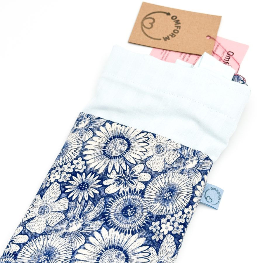 blå materiale med stribet motiv og en mørkeblå blomster mønstret lomme. Hanken er af samme materiale som lommen.