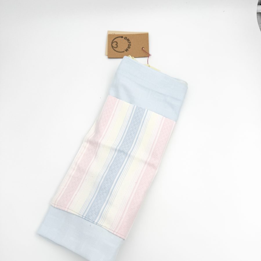 Dette net er af et lyseblåt materiale med en pastel stribet lomme med motiv. Hanken er gul.