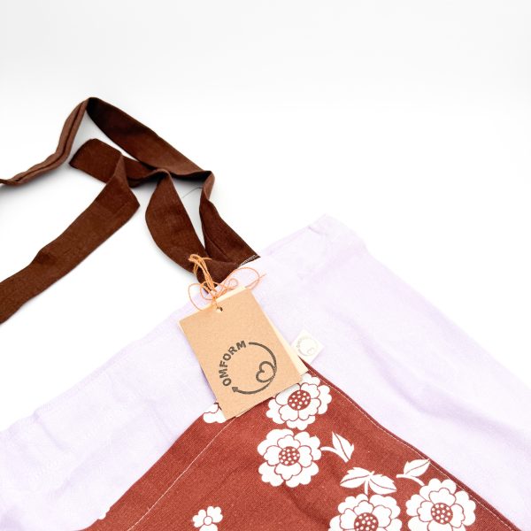 Dette net er af et lilla materiale med brun blomstret lomme og en brun hank.